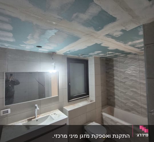 חדר אמבטיה עם כיור, מראה, ושירותים